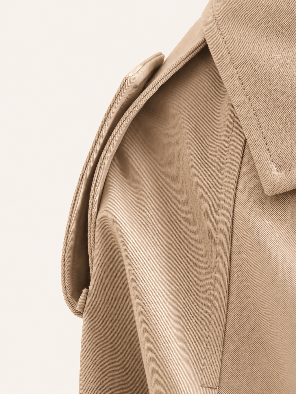 Détail de la patte d'épaule boutonnée et de la couture d'emmanchure, veste trench camel